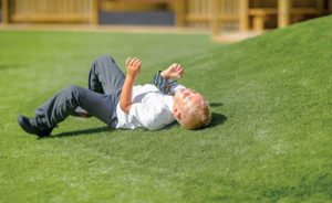 an image of a child laying on the artificial grass
