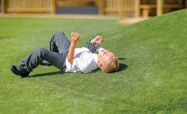 an image of a child laying on Artificial Grass
